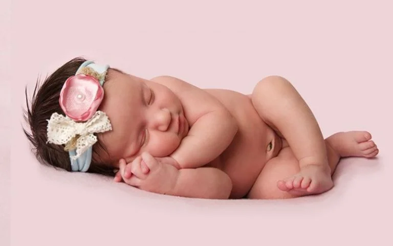 Retouched baby photo with smooth skin, soft lighting and a clean background.